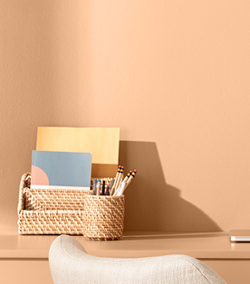 Faded terra-cotta color, Desert Carnation, on wall and desk with fiber study accessories.