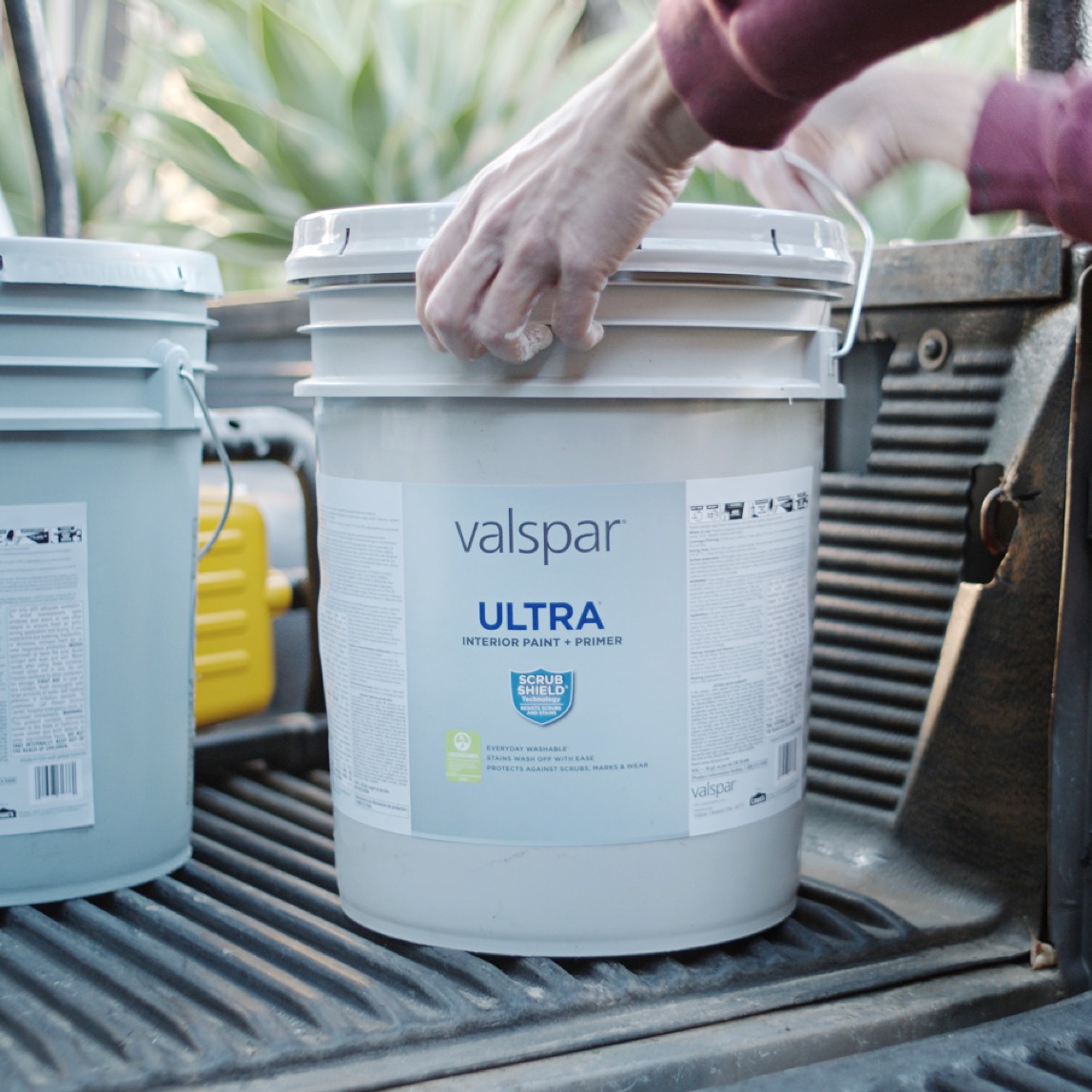 5 gallon paint bucket about to be lifted out of a truck bed