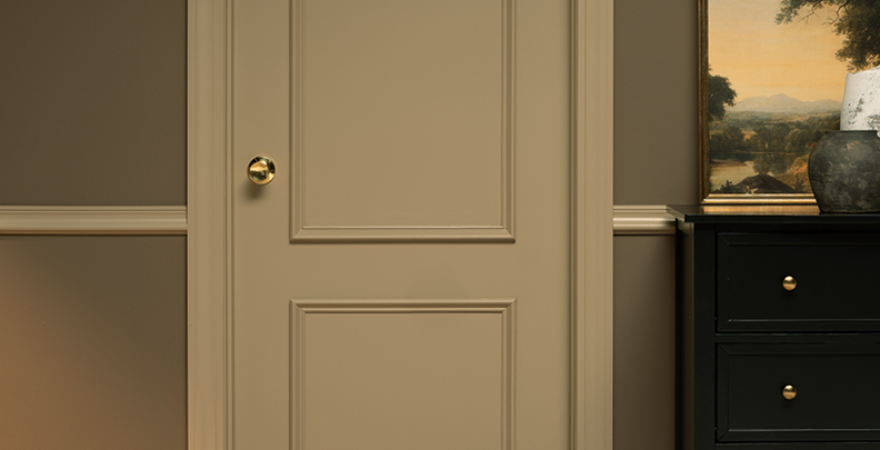 Paneled door in Faint Maple with a gold doorknob. 