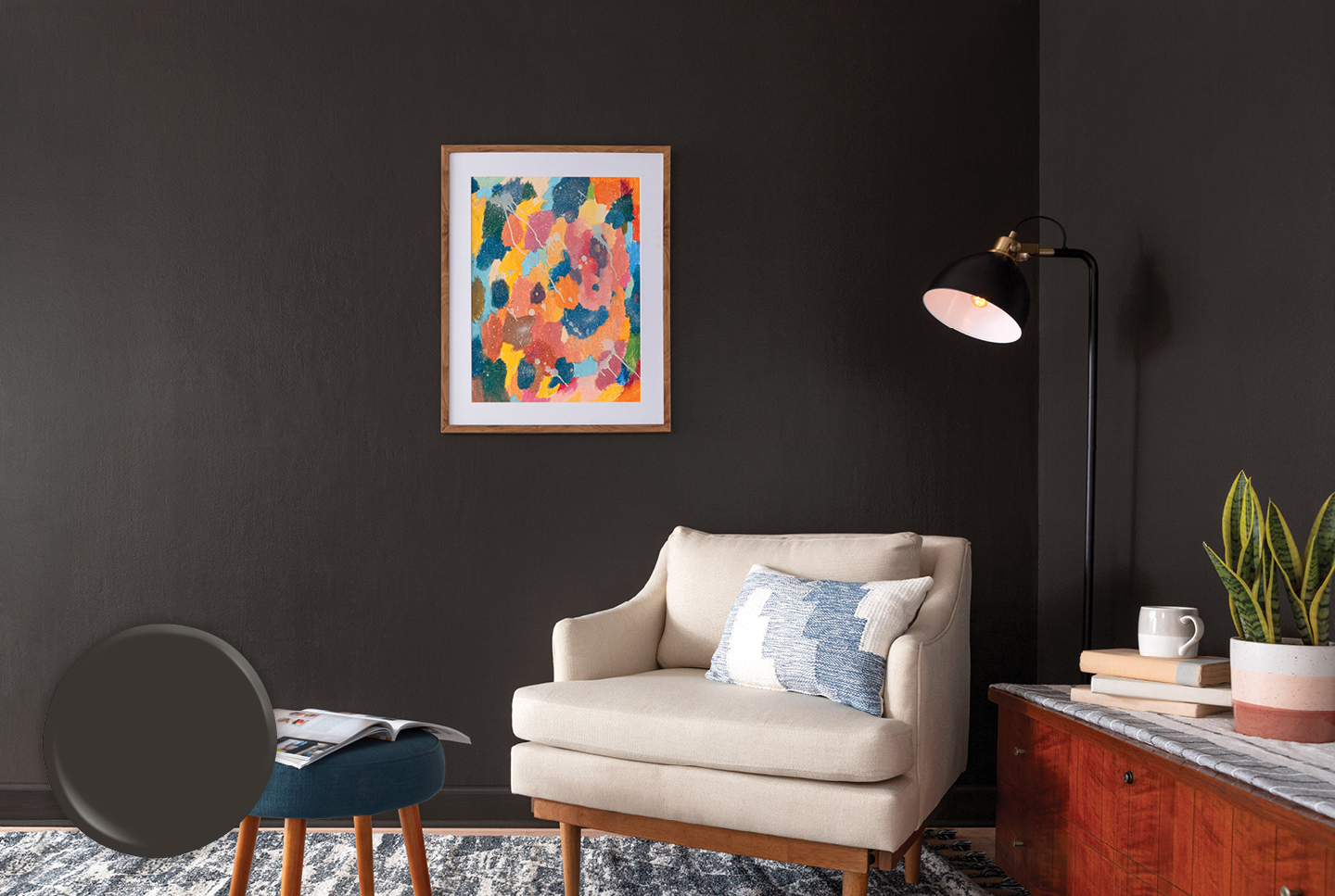 Corner view of deep-toned Fired Earth wall with standing lamp, white chair and deep-blue stool.