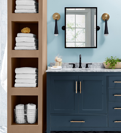 Modern bathroom with mirror and sconces, a Northern Sky Blue wall, tall Universal Umber shelving and Indigo Streamer vanity.