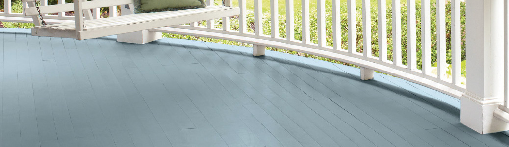 Curved, light blue wooden porch with white railing and glimpse of white porch swing.